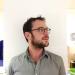 A man with glasses is standing in a room.